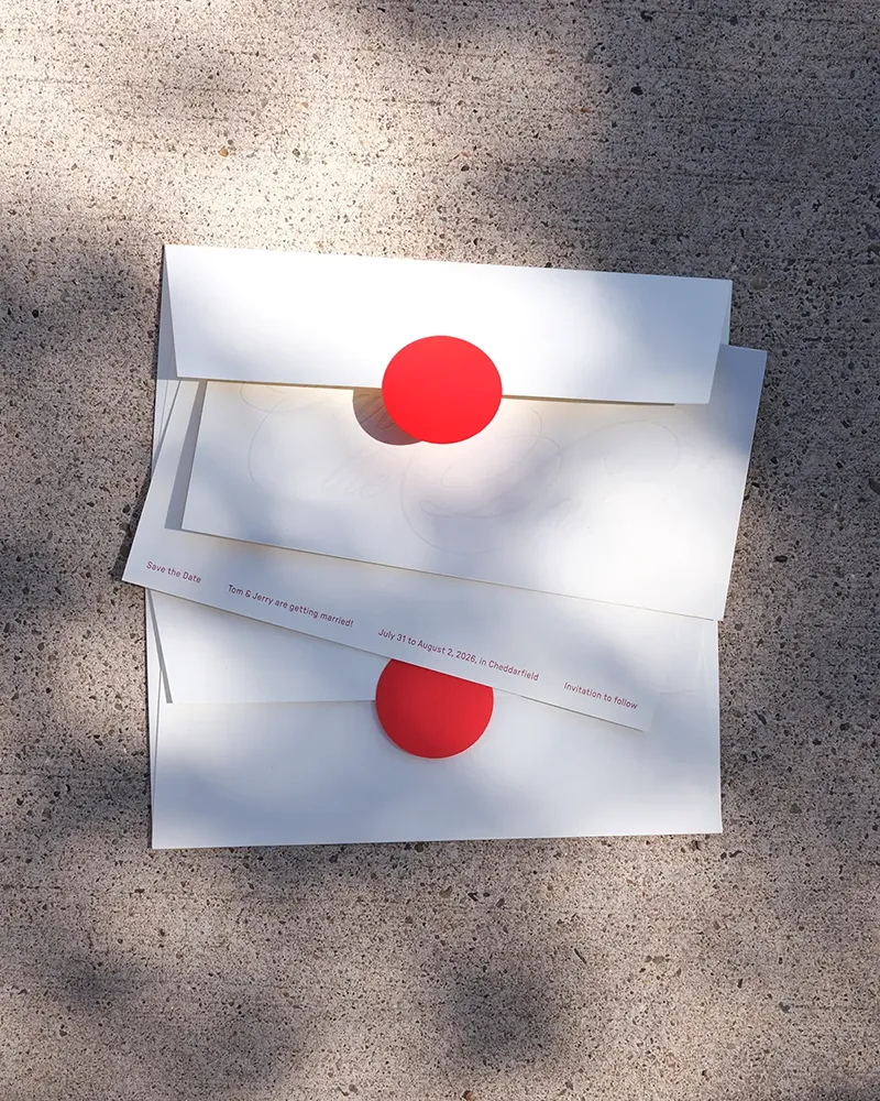 Two sets of the Aspen suite save-the-date card with bright red details.