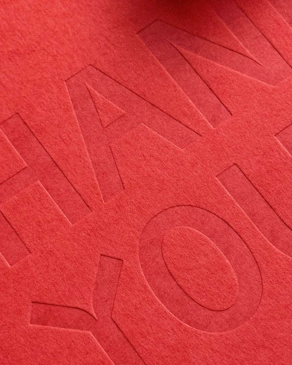 Close-up of blind debossing Kir Royal Suite thank-you card in bright red.